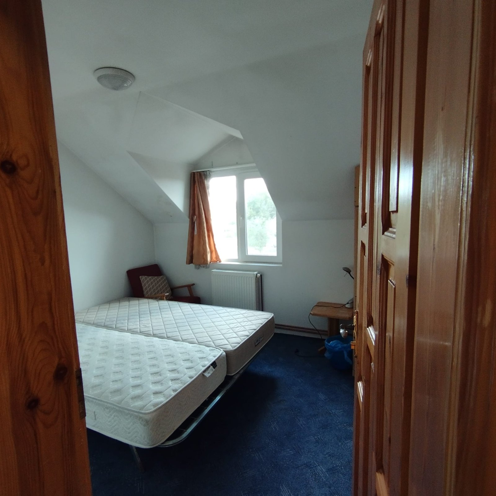 Cameră luminoasă cu paturi, situată în noua locație ACPEIO din Rotbav, destinată activităților de tabără și odihnei copiilor și voluntarilor.