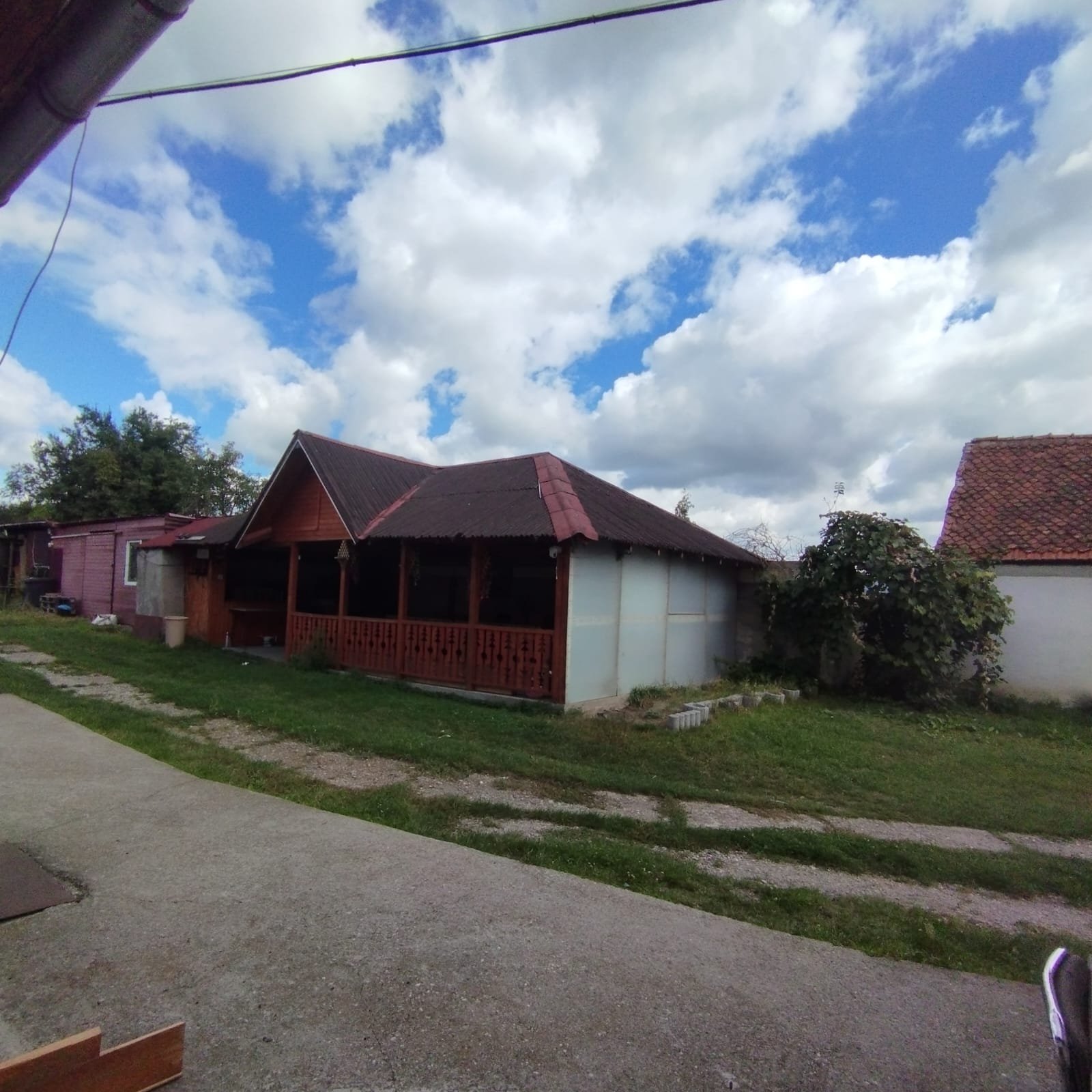 Foișor acoperit situat în curtea locației ACPEIO din Rotbav, ideal pentru activități outdoor, întâlniri, jocuri și evenimente comunitare.