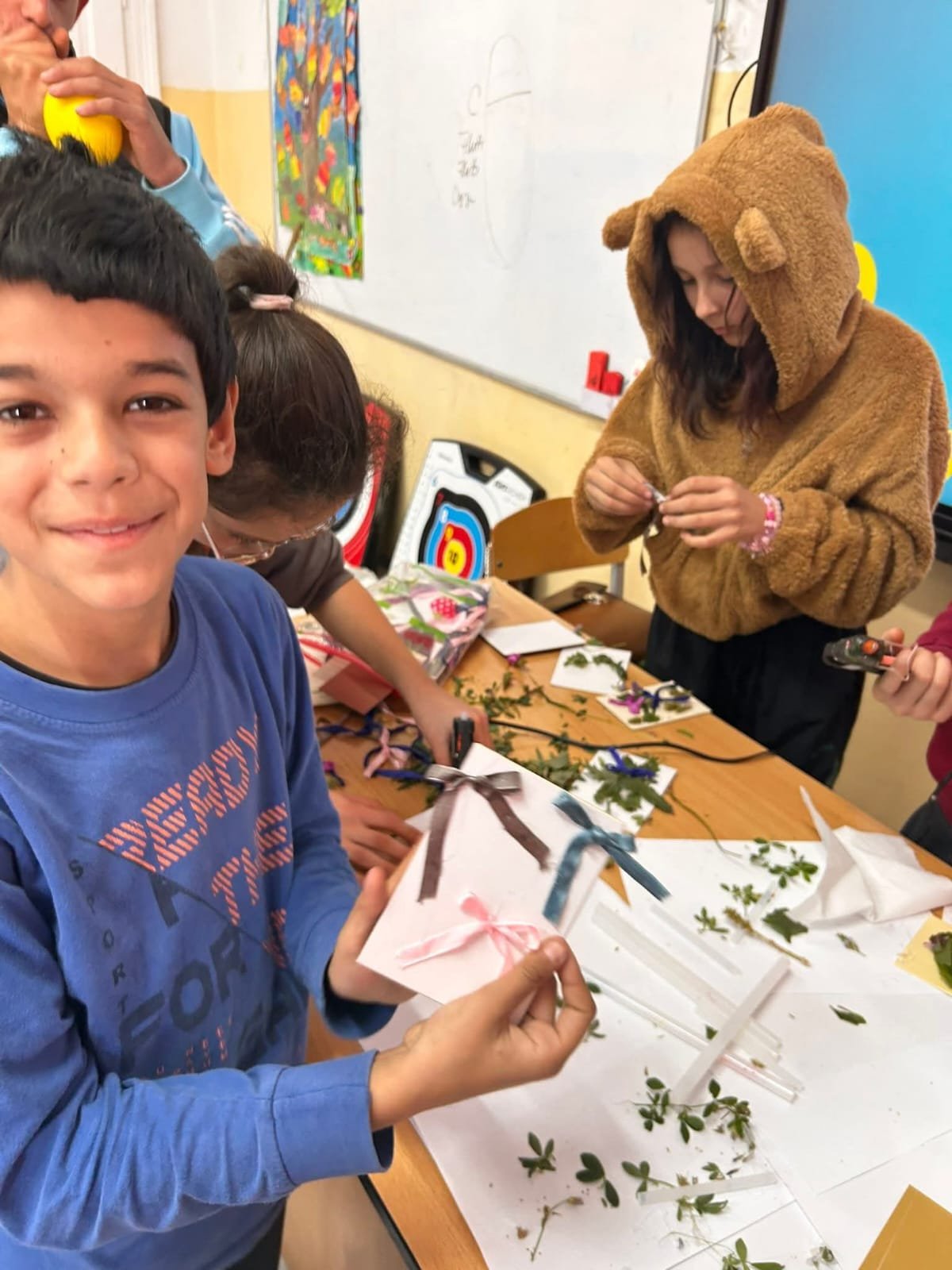 Elevi realizând colaje din plante și flori naturale în cadrul atelierului creativ de toamnă.