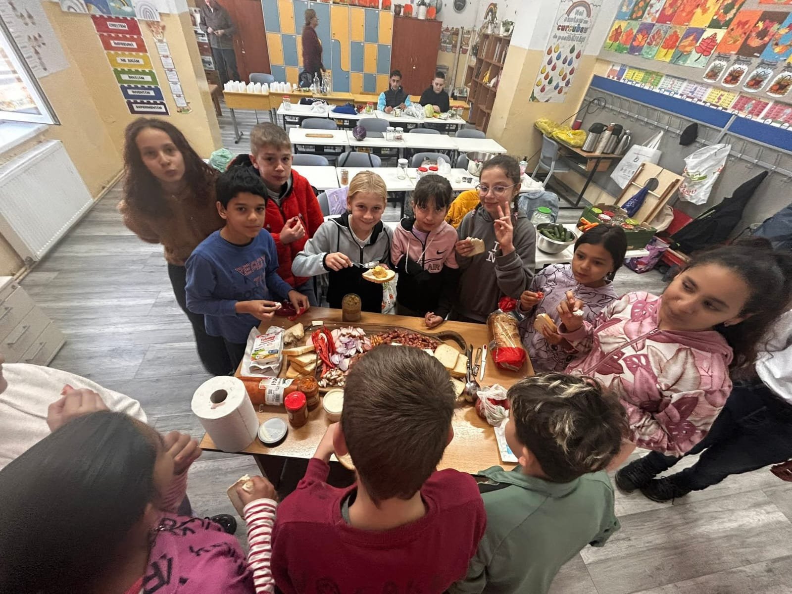 Grup de copii pregătind gustări și produse tradiționale în cadrul proiectului Culorile toamnei.