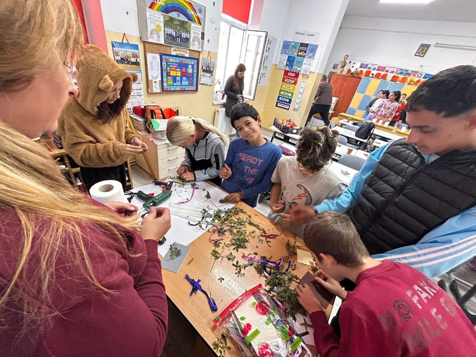 Elevi lucrând împreună la decorațiuni de toamnă