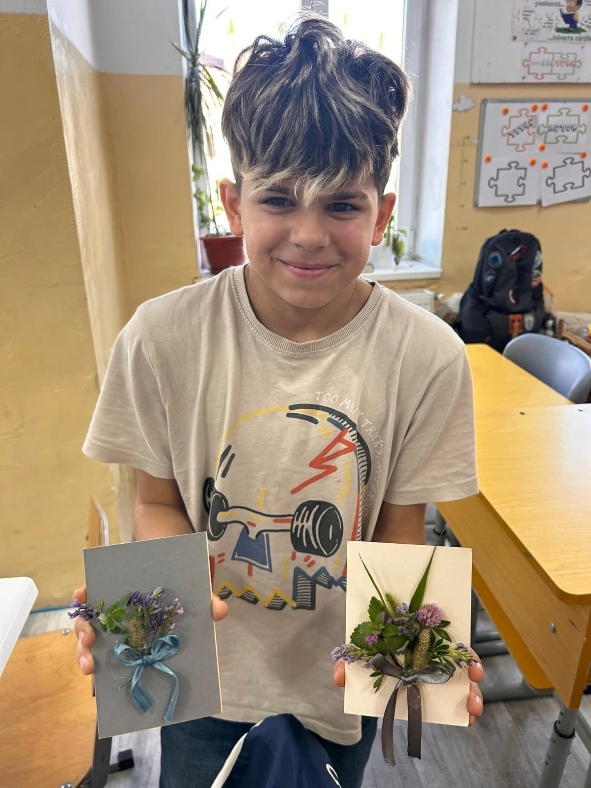 Elev prezentând două creații decorative realizate din flori și plante de toamnă în cadrul atelierului de creație.