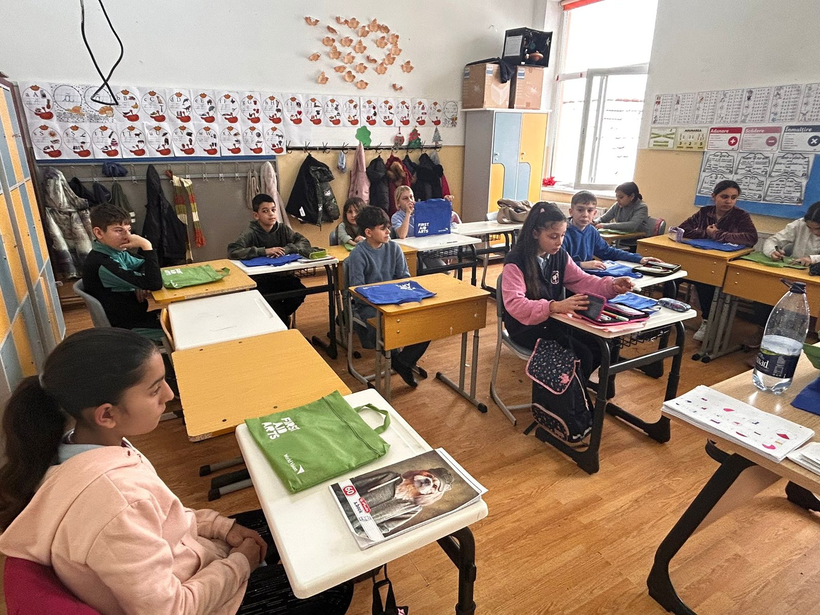 Elevii de la Școala Gimnazială Bod așezați la bănci, fiecare cu materialele First Aid Arts pregătite pentru activitatea de dezvoltare emoțională.