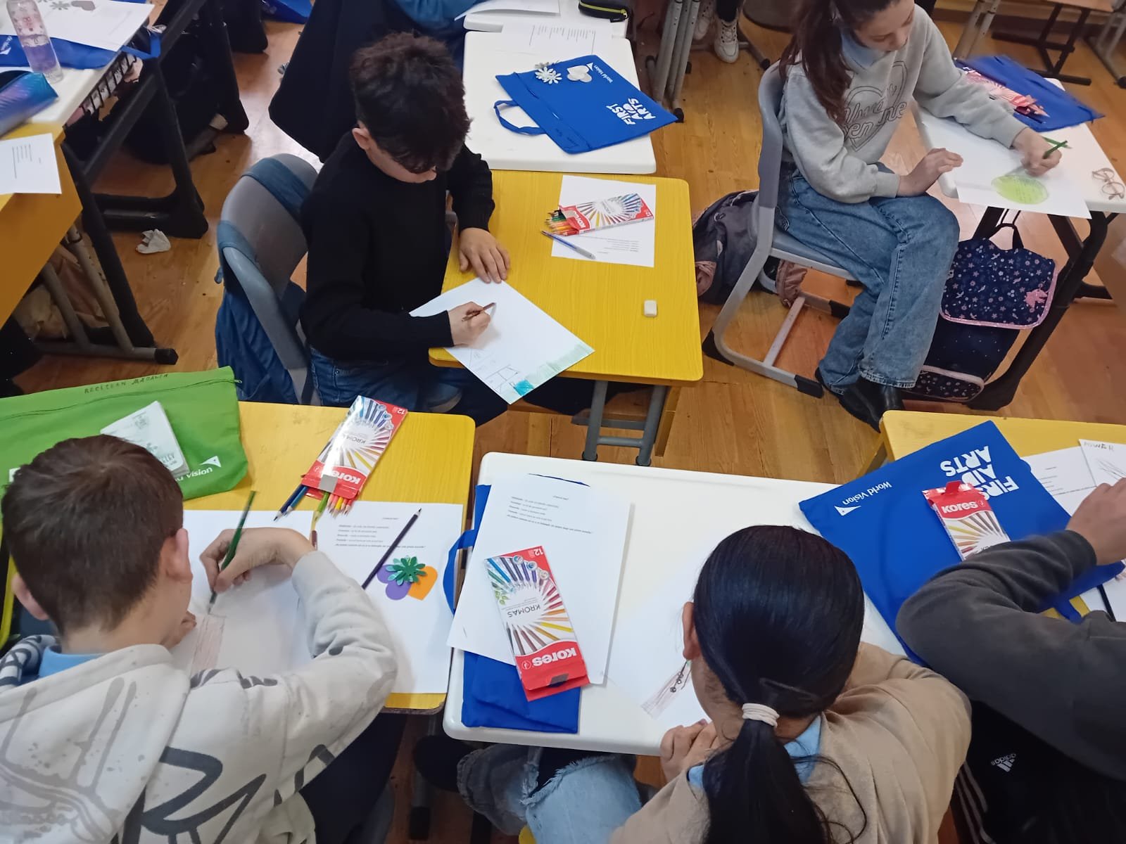 Copil concentrat desenând un copac cu creioane colorate în cadrul activității socio-educaționale de artă și reziliență