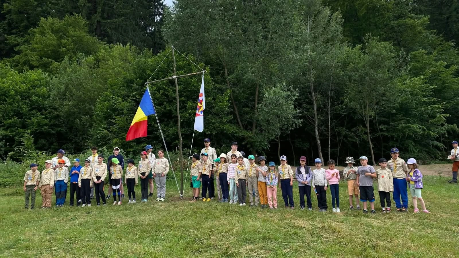 Cercetașii aliniați la ceremonia taberei de vară cu cortul