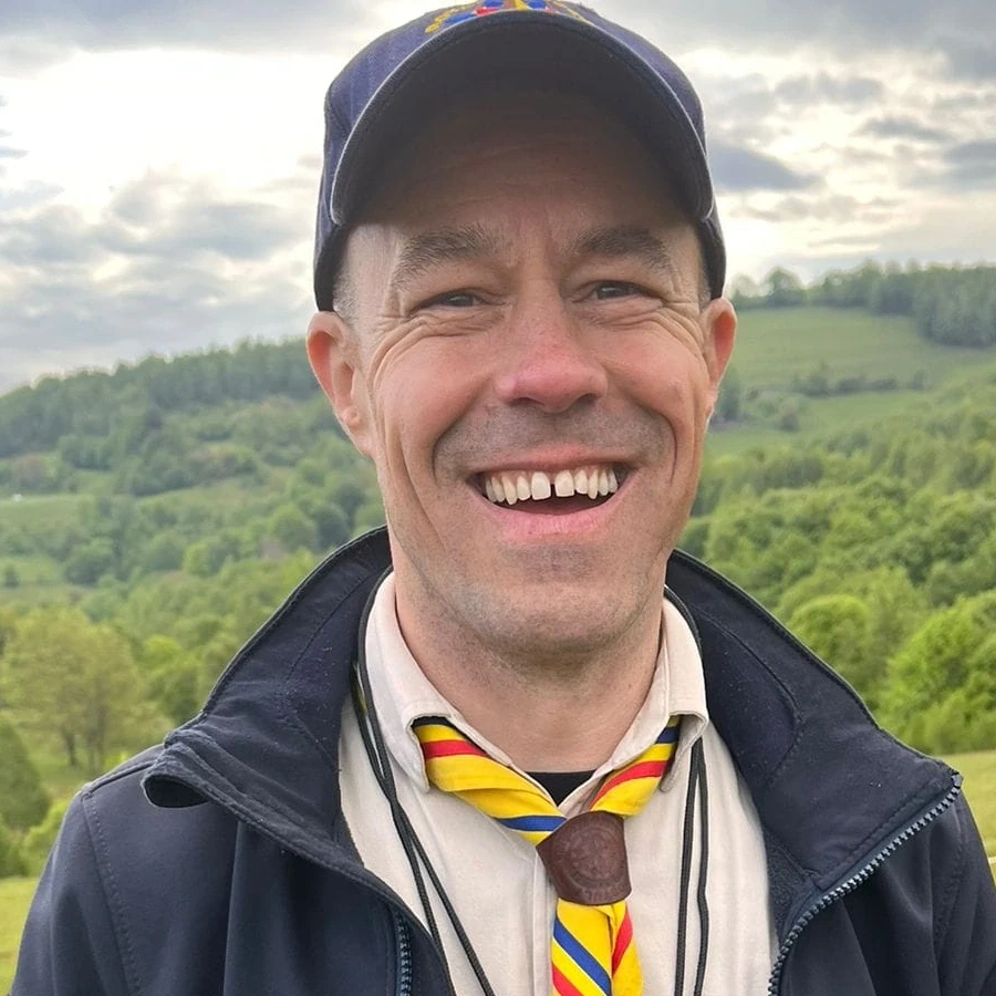Bogdan Iosif, lider de grup Royal Rangers Postul 7 Brașov, zâmbind la o tabără de pregătire pe deal